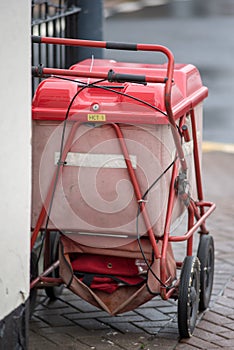 Red royal mail trolley chained to gate