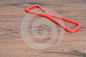 A red rubber tug of war toy for a dog