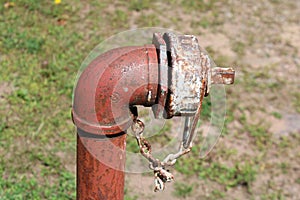 Rusted pipe in ground with chain