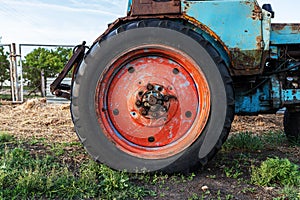 Red rusty wheel from a tractor close up