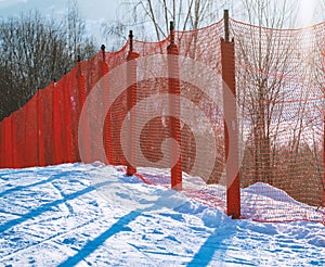 Red safety net at the edge of an alpine skiing slope