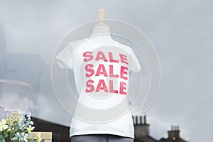 Red sale white t-shirt on female mannequin in shop window