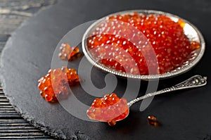 Red salmon caviar on black background