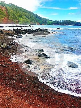 Red sand beach with lava rocks on the coast in Maui Hawaii