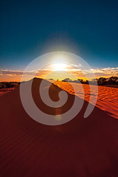 Red sand dune with ripple and blue sky