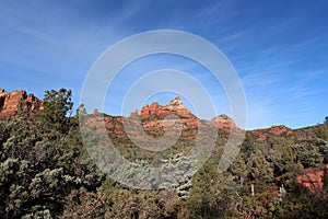 The red sandstone mountains of Sedona rising above the evergreen trees of Cococino National Forest