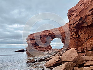 Red sandstone sea cliffs under an overcast sky at Cavendish Beach, Prince Edward Island, Canada.