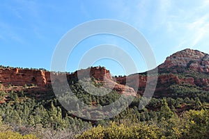 The red sandstone and white limestone mountains of Sedona rising above the evergreen trees of Cococino National Forest