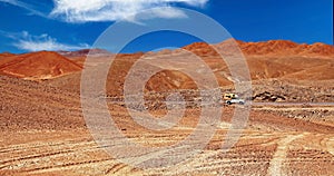 Red sandy dry arid barren valley, off orad tire tracks in sand, camper truck, mountains - Salar de Atacama, Chile