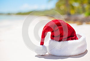 Red Santa Claus hat on beach, theme for Christmas vacation and travel