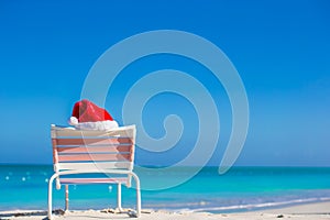 Red Santa hat on chair longue at sea shore