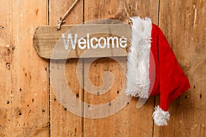 Red Santa hat hanging on a welcome sign on an old front door