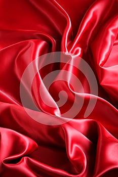 Red satin fabric with large folds, abstract background