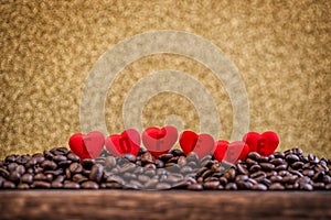 Red satin hearts on coffee beans with letters, valentines or mothers day background, love celebrating