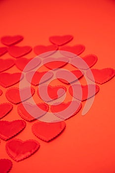 Red satin hearts on a red background. St. Valentine's Day background. Selective focus