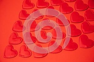 Red satin hearts on a red background. St. Valentine's Day background. Selective focus