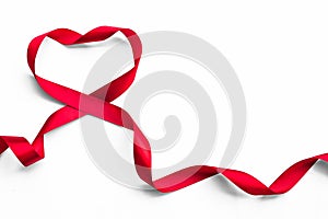 Red satin ribbon bow in heart shape isolated on white background clipping path, symbolic concept for National heart month