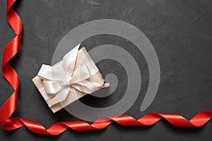 red satin ribbon on a concrete background. box with a bow. The concept of a gift for loved ones on February 14. Baner