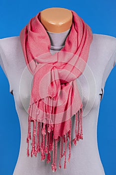 Red scarf on mannequin isolated on blue background.