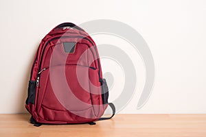Red school bag on wood table
