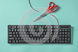 Red scissors and a keyboard with a cut wire. Idea and concept for the topic of censorship or freedom of the press