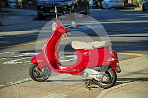 Red scooter for deliveries of food and parcel in the downtown neighborhoods of an american city in the late afternoon sun light