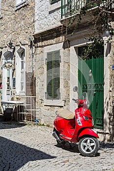 Red scooter on street of small agean village