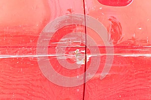 Red scratched car with damaged paint in crash accident or parking lot and dented metal body from collision