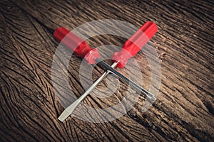 Red screwdriver on wooden background