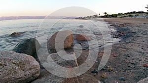 Red Sea coast at sunset. Splash of sea water among natural stones. Relaxation on vacation