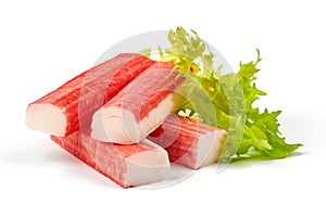 Red sea crab stick with green lettuce, close-up, isolated on white background