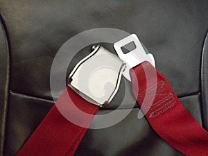 Red seat belt in Airplane to save life while flying in sky. Safety and travel concept