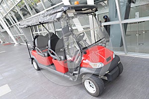 A red 6-seater open style club golf tour car parked photo