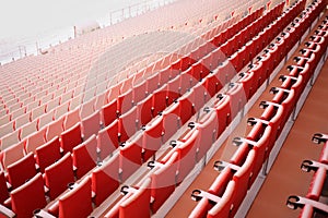 Red seats of grandstands covered by snow in modern