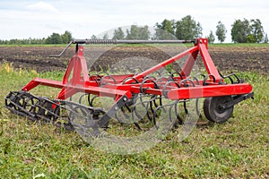 Red seedbed cultivator standing in a field