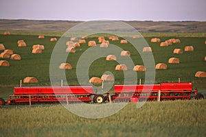 Red seeders and hay bales photo