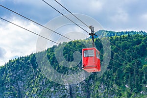 Red Seilbahn cable car gondola against Zwolferhorn mountain