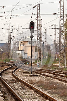 Red semaphore and railway tracks. Traffic light shows red signal on railway