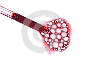 Red serum in pipette isolated on white background. Cosmetic liquid dropper