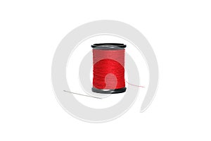 Red sewing thread in black reel with sewing needle