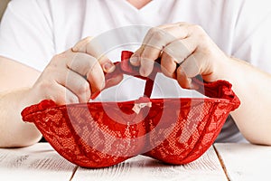 Red sexy lace bra in hands