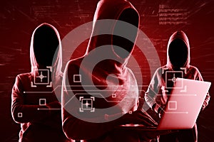 Red shadows faceless hackers in hoody using laptop and abstract virtual technological symbols, personal data theft and cyber