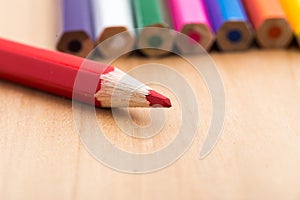 Red sharp pencil stands out from the crowd of colored, non-sharp pencils