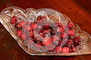Red shiny cranberries with sugar in a crystal bowl