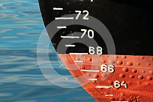 Red ship hull with waterline and draft scale measure