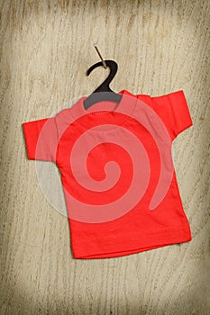 Red shirt on black hanger hanging on nail