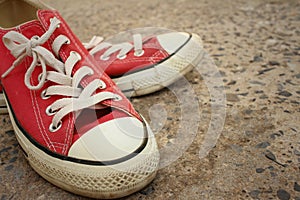 Red shoes on the floor of cement.