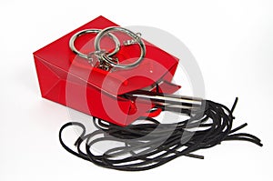 Red shopping bag with flogging whip and handcuff photo