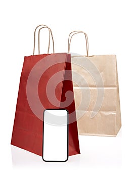 Red shopping bags with empty smartphone screen on a white background