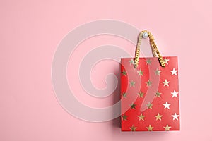 Red shopping paper bag with star pattern on background, space for text